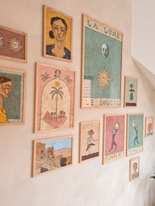 gallery wall of colorful art prints in soft and muted pink, yellow and green tones